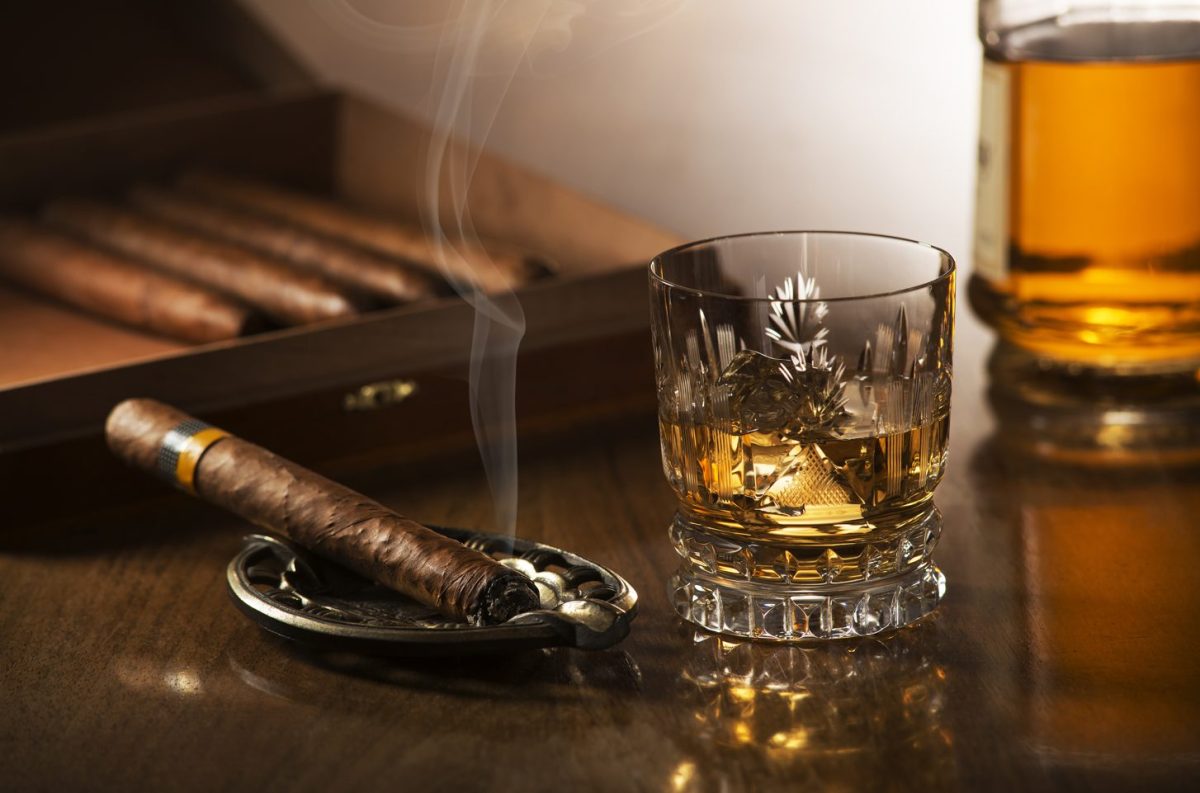 Smoking cigar and drink whisky